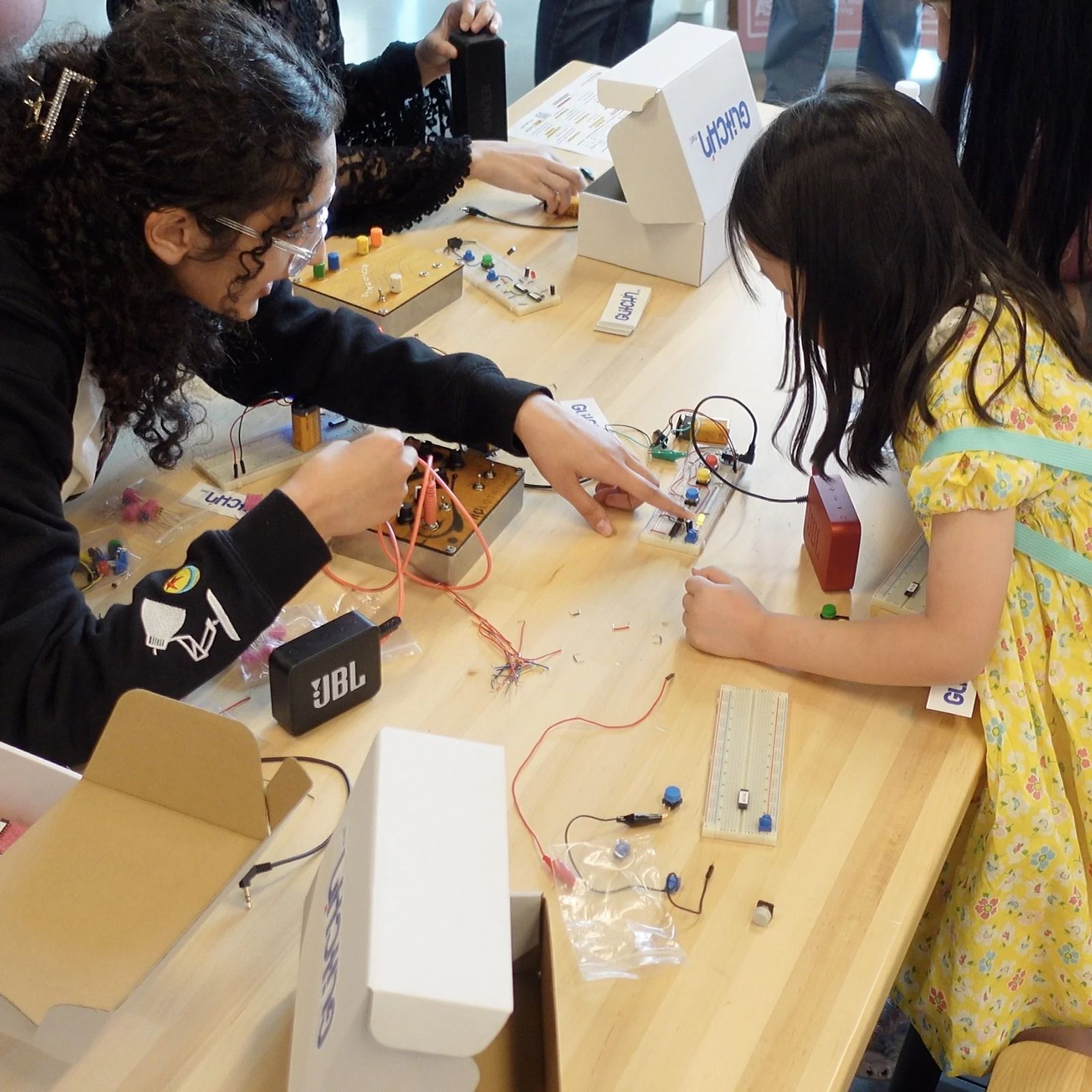 Young people building a sound circuit on a breadboard